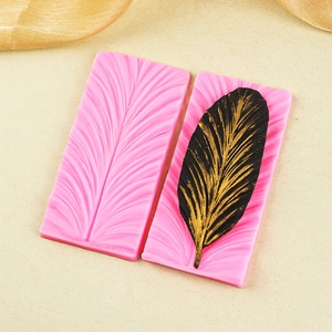 Pink silicone feather mold for fondant or chocolate with detailed peacock leaf texture