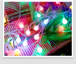 Close-up of multicolored solar LED star string lights in a rustic wicker basket setup