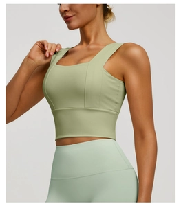 Detailed view of the square neck design and wide shoulder straps on a light green sports bra
