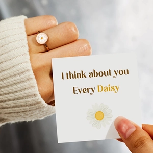 Daisy flower ring on model hand with a gift card saying I think about you Every Daisy