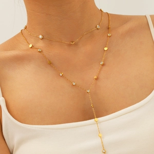 Gold plated layered necklace with round zircon stone pendant and tassel on model