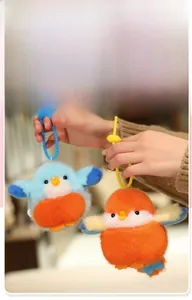 Détail d'un porte-clés oiseau en peluche douce avec sangle en silicone et module sonore