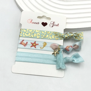 Detail of light blue and gold elastic hair ties with leopard print and sea star charms
