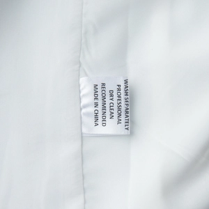 Detailed view of the garment care label with washing instructions and fabric texture