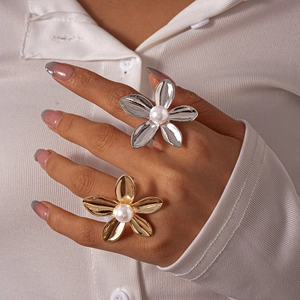 Detail shot of pearl flower rings in gold and silver finish on model's hand
