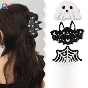 Macro detail of bat, ghost, spiderweb and pumpkin acrylic hair claws for Halloween