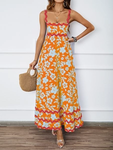 Close-up of orange floral summer maxi dress featuring red wavy trim and elegant halter neck