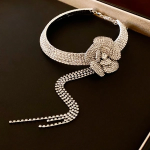 Detailed view of silver flower choker with sparkling rhinestone tassels on black velvet box