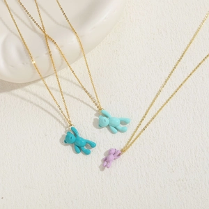 Detailed view of colorful bear pendants in blue and purple on elegant gold-tone chains