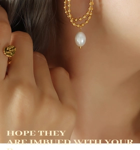 Detailed close-up of gold beaded chain earrings with pearls and a rose-shaped ring
