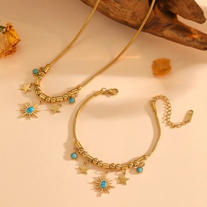 Detailed view of gold link chain set with turquoise sun pendant and star charms