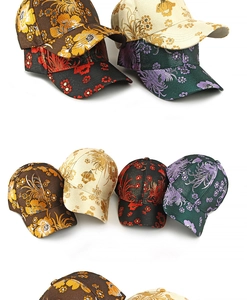 Detailed close-up of intricate Chinese floral embroidery on satin baseball caps