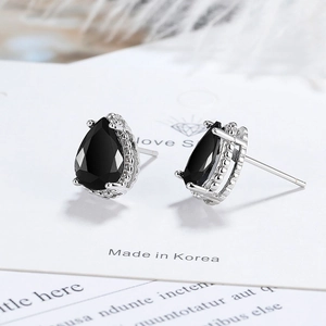 Elegant pear cut black zircon stud earrings in silver prong setting on white display card