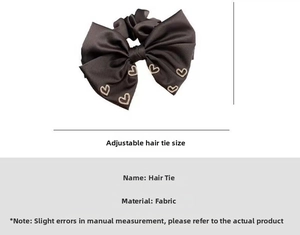 Detailed view of dark silk fabric hair tie with crystal heart accent and adjustable size
