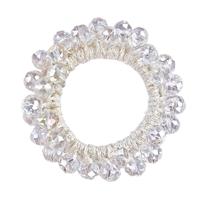 Close-up of sparkling faceted crystal beads on an elastic beige woven hair tie