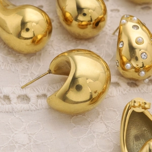 Polished 18K gold teardrop and pearl chunky hoop earrings on white lace background