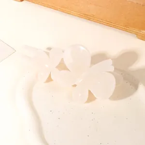 Detail of a creamy white butterfly hair clip set on a decorative ceramic display plate