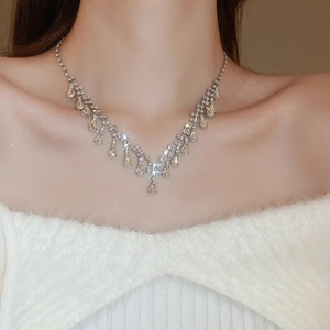 Close-up of sparkling waterdrop tassel necklace with crystals on model neck