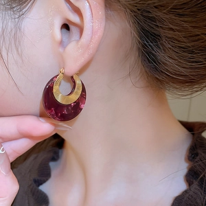 Close-up of vintage acetate marble hoop earring with golden textured metal detail