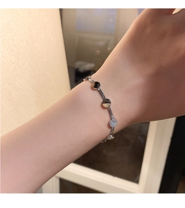 Makro-Detail des silbernen Schlangenkette-Armbands mit flachen runden Metallscheiben
