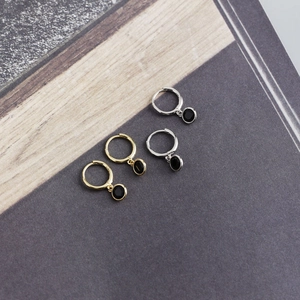 Detail of S925 silver hoop earrings with black zircon charms in gold and silver finish