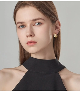 Close-up of elegant triple-layered gold hoop earrings worn by a female model