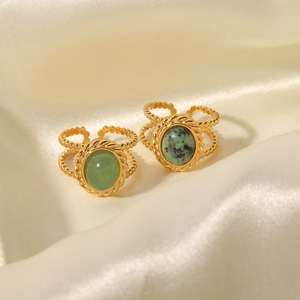 Vintage gold open rings with oval green turquoise on elegant beige silk fabric