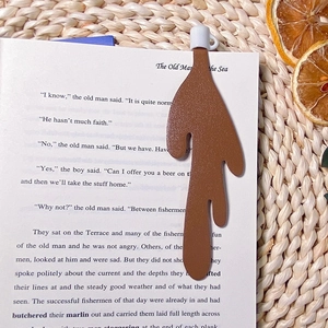 Creative brown spilled coffee bookmark on open book pages with cozy lifestyle decor