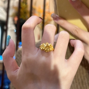 Detailed view of matte gold floral cluster ring featuring textured five-petal blossoms
