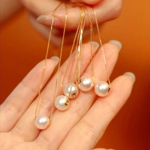 Close-up of five S925 silver necklaces with golden chains and elegant freshwater pearls