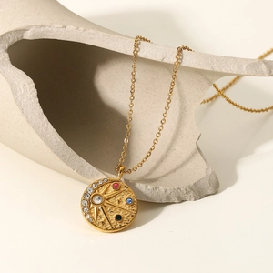 Détail macro du pendentif soleil et lune en or 18 carats avec zircons colorés