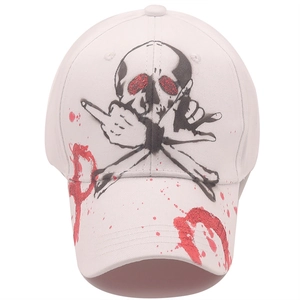 White baseball cap featuring a black skull print and red graffiti art with glitter