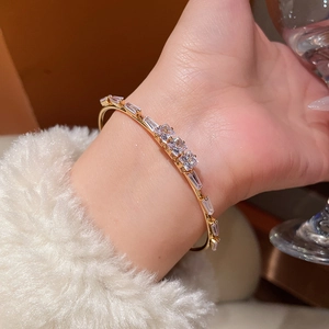 Elegant 18K gold-plated open bangle with square cubic zirconia on a wrist with white fur