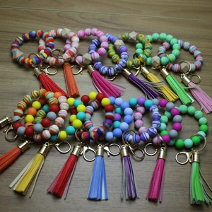 Macro detail of silicone bead wristlet keychain with wooden accents and fringe tassel
