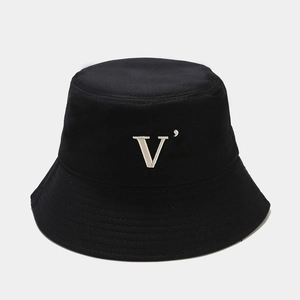 Détail d'un chapeau bob en coton noir avec broderie blanche de la lettre V texturée