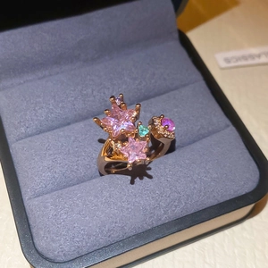 Close-up of rose gold star ring with pink and blue crystals in a blue velvet box