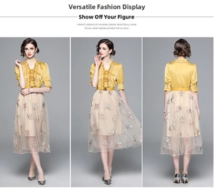 Detail view of yellow silk-like blouse and white tulle skirt with butterfly embroidery