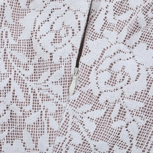 Détail de dentelle blanche avec fermeture éclair invisible sur une robe à épaules dénudées