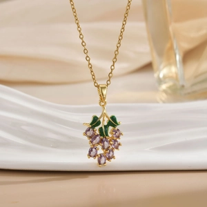 Elegant purple grape pendant necklace with zircon and gold chain on silk background