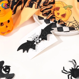 Halloween bat wing hair clip with skull detail and spooky holiday props arrangement