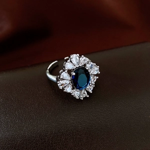 Close-up of luxury teardrop zircon ring with blue oval gemstone and silver band