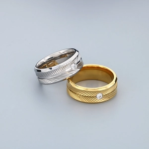 Macro detail of feather pattern texture and single diamond on gold and silver rings