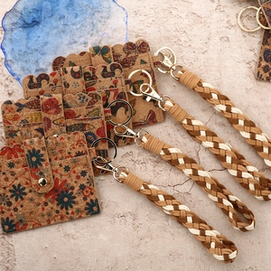 Cork card holder wallet with braided wristlet and scalloped edges featuring floral patterns