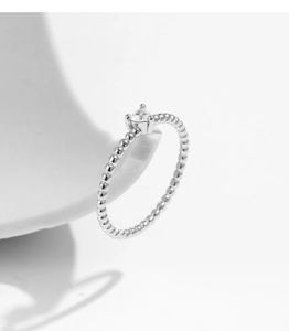 Macro shot of silver beaded ring band featuring a sparkling heart-shaped moissanite gem