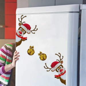 Close-up of reindeer and golden bells magnetic stickers on a white refrigerator door