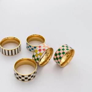 Detail of wide geometric enamel rings featuring colorful checkered and striped patterns