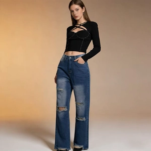 Close-up of high-waisted wide-leg jeans with distressed fringe and ripped knee details