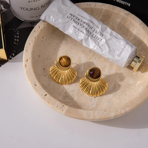 Gedetailleerd beeld van de waaiervormige 18K gouden oorbellen met bruine parels in set