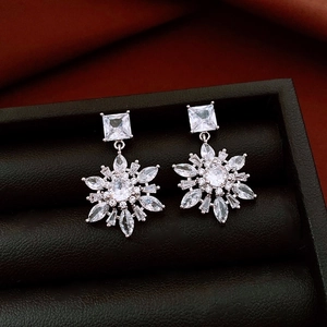 Detailed close-up of 14k gold plated snowflake drop earrings with clear zircon stones
