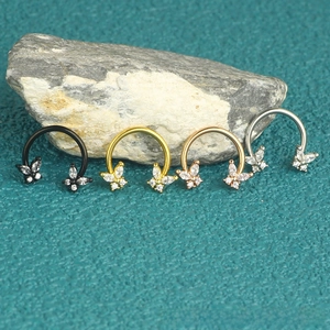Detail showing butterfly horseshoe rings in black, gold, and silver on stone